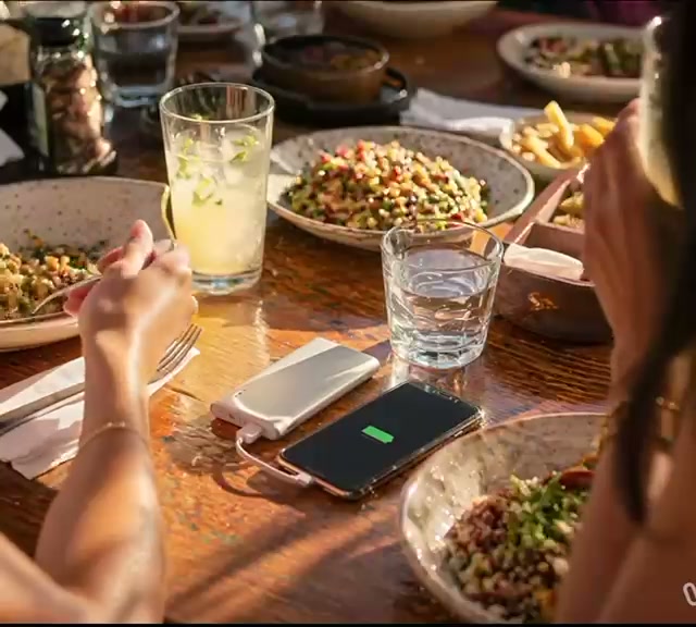 טלפון נטען ממטען נייד של VoltGo על שולחן בבית קפה
